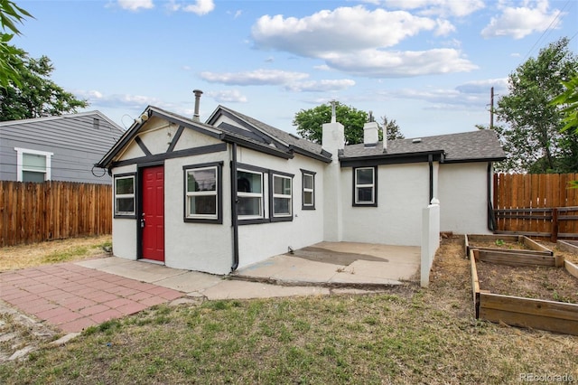 1301 Kenton St, Aurora, CO 80010 - rear view of property featuring a vegetable garden, a patio area, stucco siding, and a fenced backyard