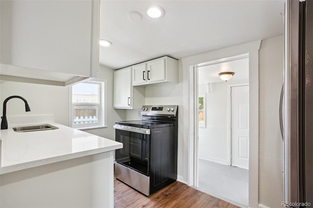 1301 Kenton St, Aurora, CO 80010 - kitchen featuring appliances with stainless steel finishes, light wood-style floors, white cabinets, light stone countertops, and recessed lighting