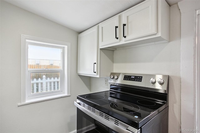 1301 Kenton St, Aurora, CO 80010 - kitchen with stainless steel electric stove and white cabinetry