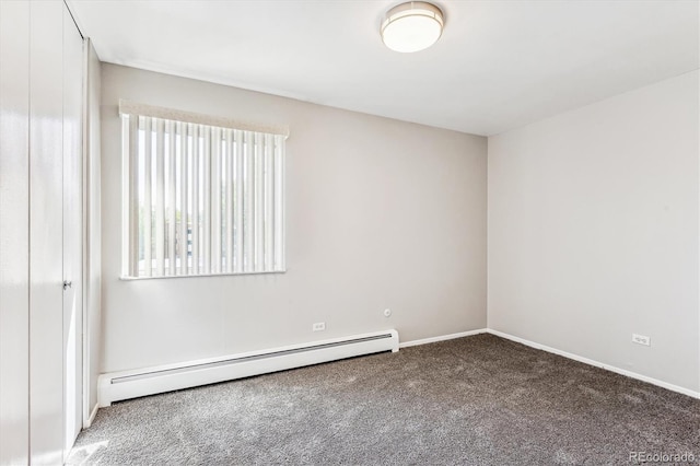 spare room featuring a baseboard heating unit and carpet flooring