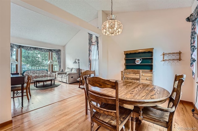 5362 S Danube Ct, Centennial, CO 80015 - dining area featuring lofted ceiling, a chandelier, light wood finished floors, and a textured ceiling