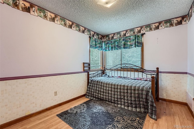 5362 S Danube Ct, Centennial, CO 80015 - bedroom with wood finished floors, a textured ceiling, and wallpapered walls