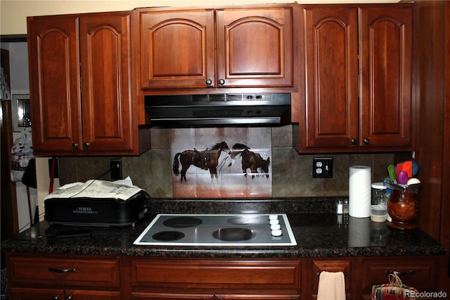 kitchen with dark stone countertops, electric cooktop, and backsplash