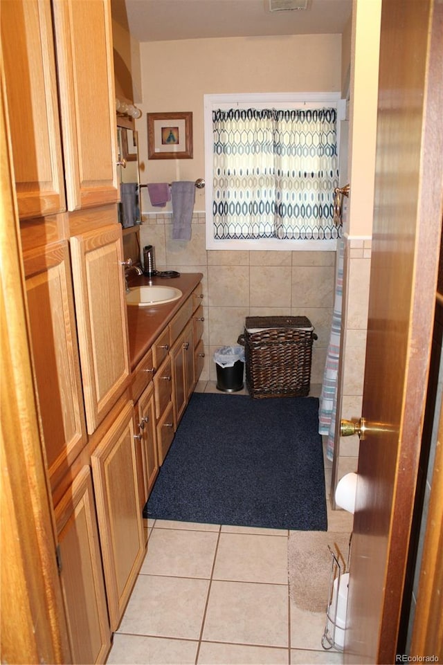 bathroom featuring tile flooring, vanity, and tile walls