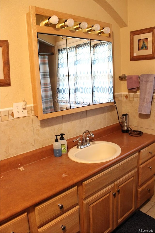 bathroom featuring vanity and tasteful backsplash