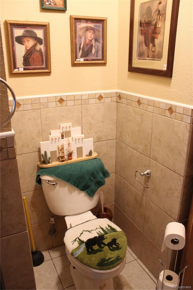 bathroom featuring toilet, tile flooring, and tile walls