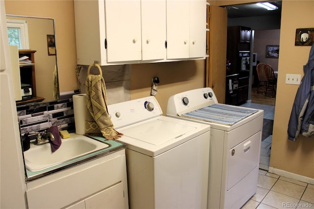 laundry area with sink, independent washer and dryer, light tile floors, and cabinets