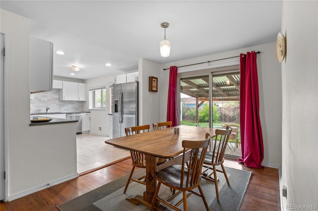 dining space featuring baseboards, recessed lighting, and wood finished floors