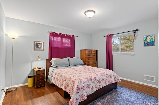 bedroom with visible vents, dark wood finished floors, and baseboards