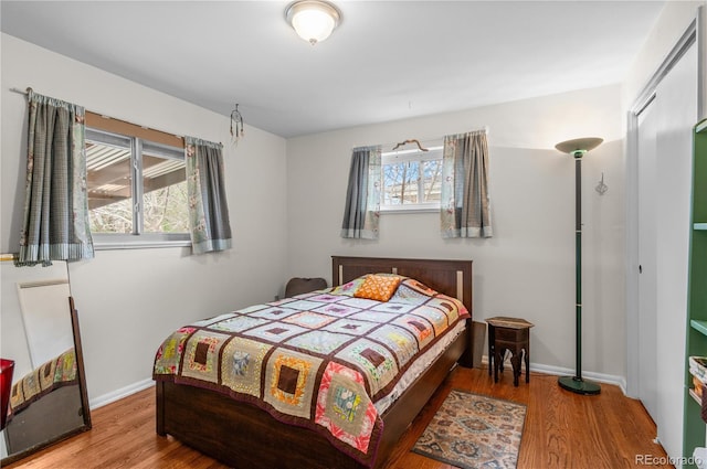 bedroom with baseboards and wood finished floors