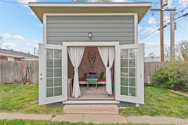 view of outdoor structure with fence and an outbuilding