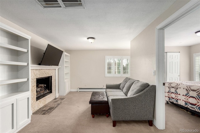 carpeted living room with a baseboard heating unit, a fireplace, visible vents, and a textured ceiling