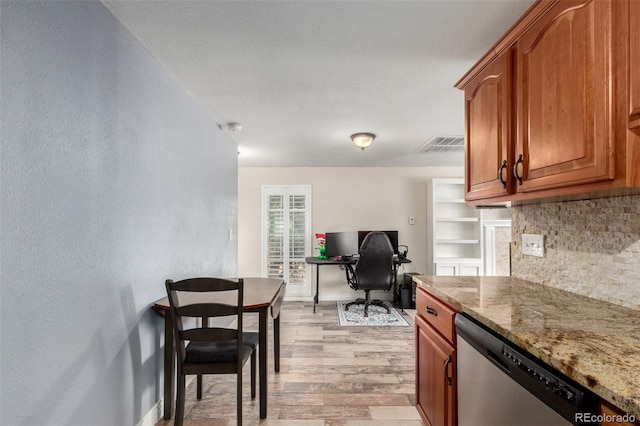 kitchen featuring light stone counters, decorative backsplash, dishwasher, and visible vents