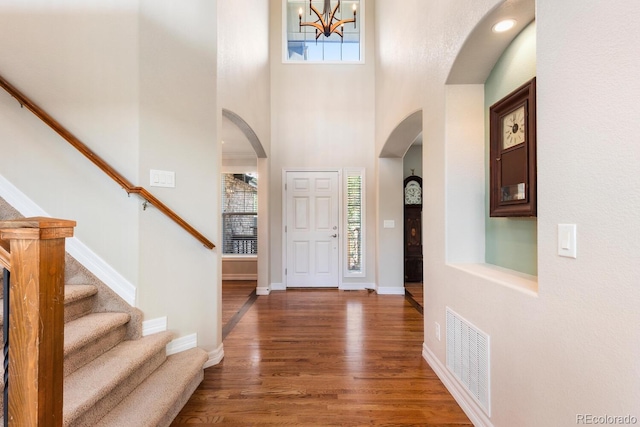 1519 Stonehill Ct, Castle Rock, CO 80104 - foyer featuring arched walkways, wood finished floors, stairs, a chandelier, and a towering ceiling