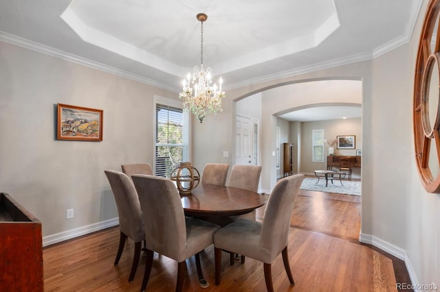 1519 Stonehill Ct, Castle Rock, CO 80104 - dining space featuring arched walkways, a chandelier, wood finished floors, baseboards, and ornamental molding