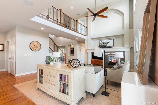 1519 Stonehill Ct, Castle Rock, CO 80104 - living room featuring ceiling fan, arched walkways, light wood-type flooring, stairway, and baseboards