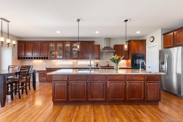 1519 Stonehill Ct, Castle Rock, CO 80104 - kitchen featuring appliances with stainless steel finishes, a sink, wall chimney range hood, an island with sink, and recessed lighting