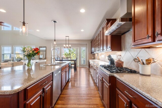 1519 Stonehill Ct, Castle Rock, CO 80104 - kitchen with wall chimney exhaust hood, a sink, stainless steel dishwasher, decorative backsplash, and light wood finished floors