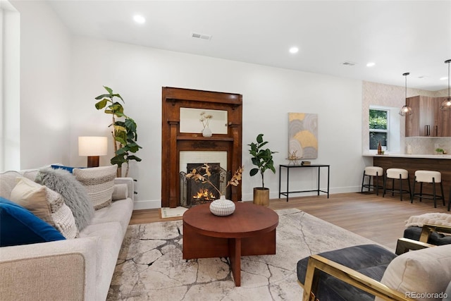 2849 N Vine St, Denver, CO 80205 - living area with light wood finished floors, a lit fireplace, and recessed lighting