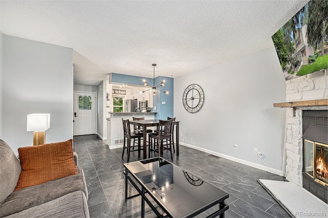 9519 W Coal Mine Ave Unit F, Littleton, CO 80123 - living room featuring a fireplace, a chandelier, and a textured ceiling
