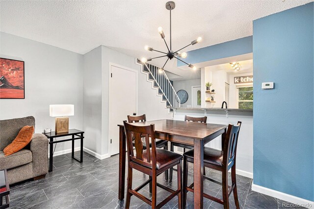 9519 W Coal Mine Ave Unit F, Littleton, CO 80123 - dining area featuring a chandelier, stairs, dark marble finish flooring, and a textured ceiling