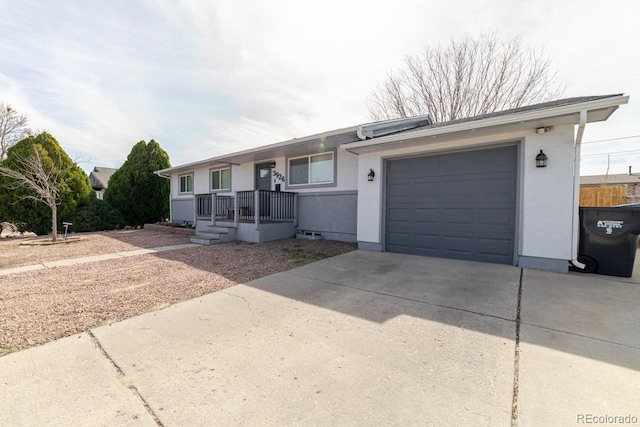 single story home with concrete driveway, an attached garage, and stucco siding