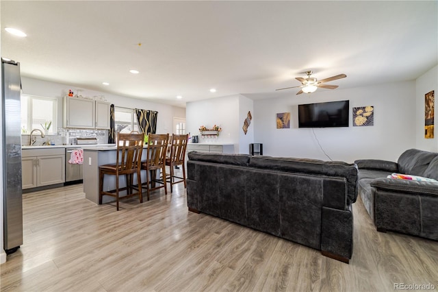 living area featuring a ceiling fan, recessed lighting, and light wood-type flooring