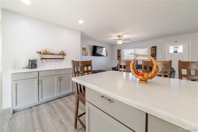 kitchen with gray cabinetry, light wood-style flooring, and light countertops