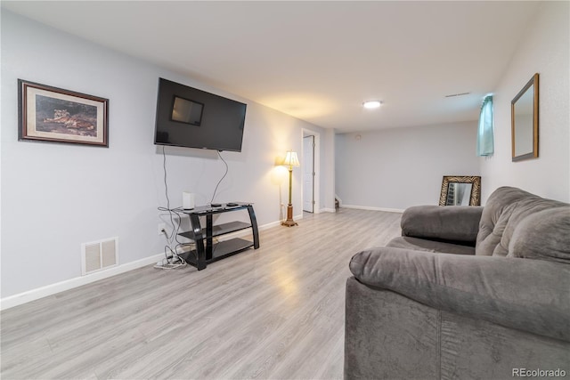 living room with baseboards, visible vents, and light wood finished floors