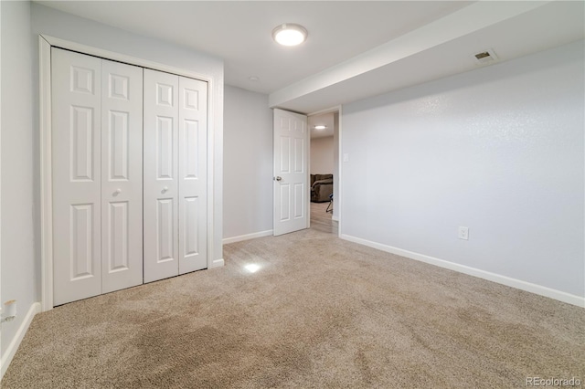 unfurnished bedroom with visible vents, baseboards, carpet, and a closet