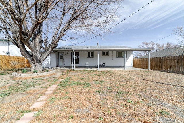 rear view of property featuring fence and a patio area