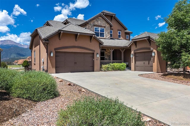3012 Cathedral Park Vw, Colorado Springs, CO 80904 - view of front facade featuring a garage, driveway, stucco siding, a tile roof, and a mountain view