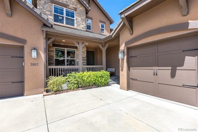 3012 Cathedral Park Vw, Colorado Springs, CO 80904 - doorway to property featuring stucco siding, stone siding, a porch, and a garage