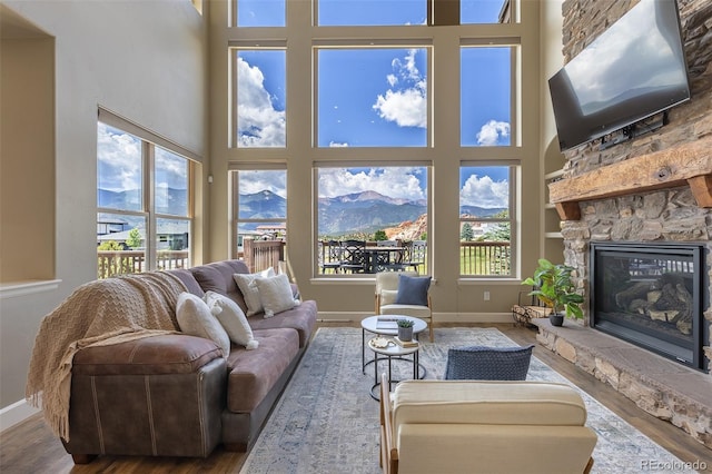 3012 Cathedral Park Vw, Colorado Springs, CO 80904 - living room with a high ceiling, wood finished floors, a mountain view, and a stone fireplace