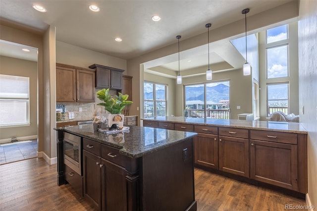3012 Cathedral Park Vw, Colorado Springs, CO 80904 - kitchen featuring a kitchen island, stainless steel microwave, plenty of natural light, dark stone countertops, and recessed lighting