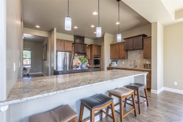 3012 Cathedral Park Vw, Colorado Springs, CO 80904 - kitchen with appliances with stainless steel finishes, backsplash, a kitchen breakfast bar, a peninsula, and dark wood finished floors