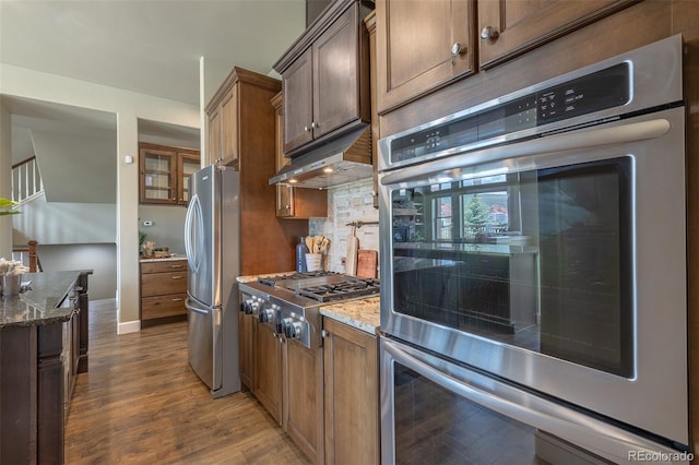 3012 Cathedral Park Vw, Colorado Springs, CO 80904 - kitchen featuring appliances with stainless steel finishes, under cabinet range hood, dark wood-style floors, and dark stone counters
