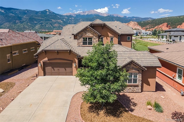 3012 Cathedral Park Vw, Colorado Springs, CO 80904 - view of front of property featuring stone siding, a mountain view, stucco siding, driveway, and an attached garage