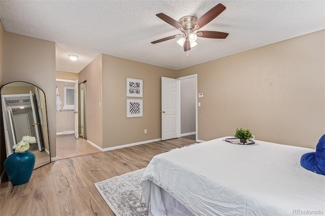 7719 S Jackson Cir, Centennial, CO 80122 - bedroom featuring light wood-type flooring, a textured ceiling, a ceiling fan, and connected bathroom