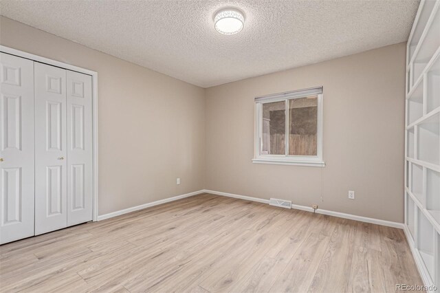 7719 S Jackson Cir, Centennial, CO 80122 - unfurnished bedroom featuring a closet, a textured ceiling, and wood finished floors