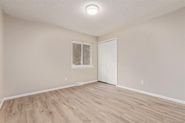 7719 S Jackson Cir, Centennial, CO 80122 - unfurnished bedroom featuring light wood-style floors, a closet, and a textured ceiling