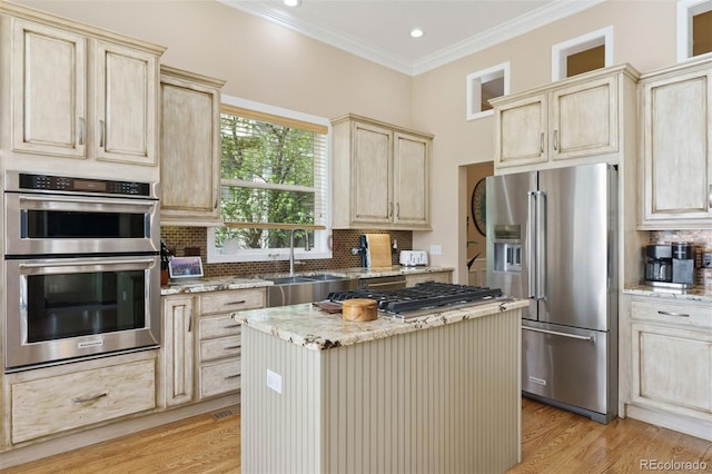 8528 Winter Berry Dr, Castle Pines, CO 80108 - kitchen with stainless steel appliances, a sink, backsplash, light wood-style floors, and light stone counters