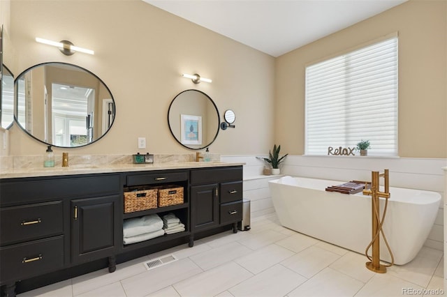 8528 Winter Berry Dr, Castle Pines, CO 80108 - full bath with a wainscoted wall, visible vents, a soaking tub, and double vanity