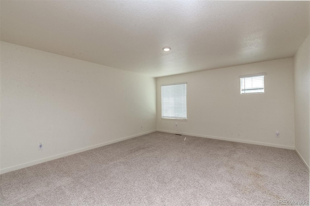 carpeted empty room with a textured ceiling