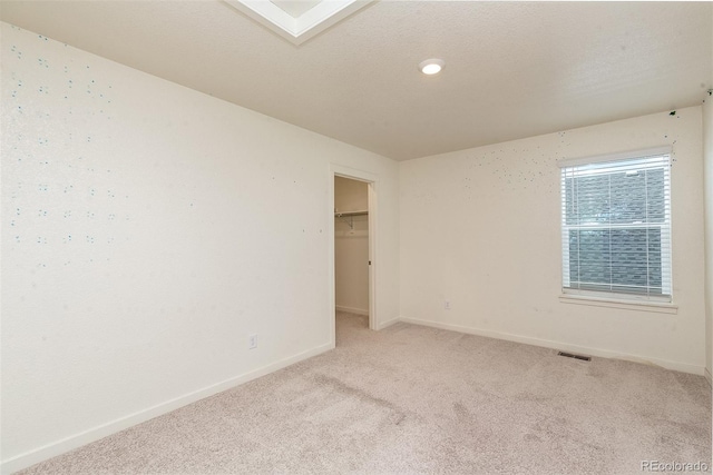 spare room with light carpet and a skylight