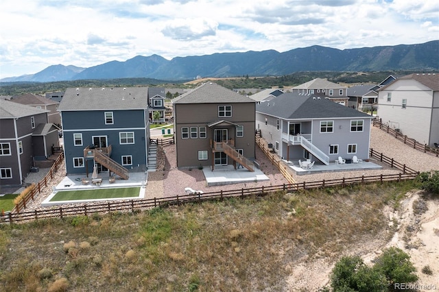 back of property with a mountain view and a patio