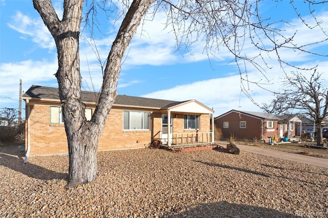 single story home with brick siding and covered porch