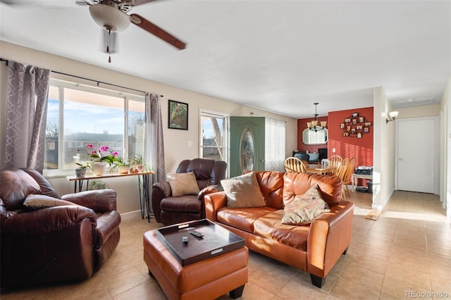 living area featuring light tile patterned floors, baseboards, and a ceiling fan