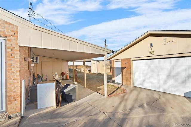 view of patio / terrace featuring a garage, an outbuilding, and a carport