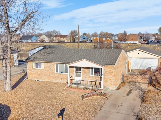 ranch-style home featuring brick siding, a residential view, and roof with shingles